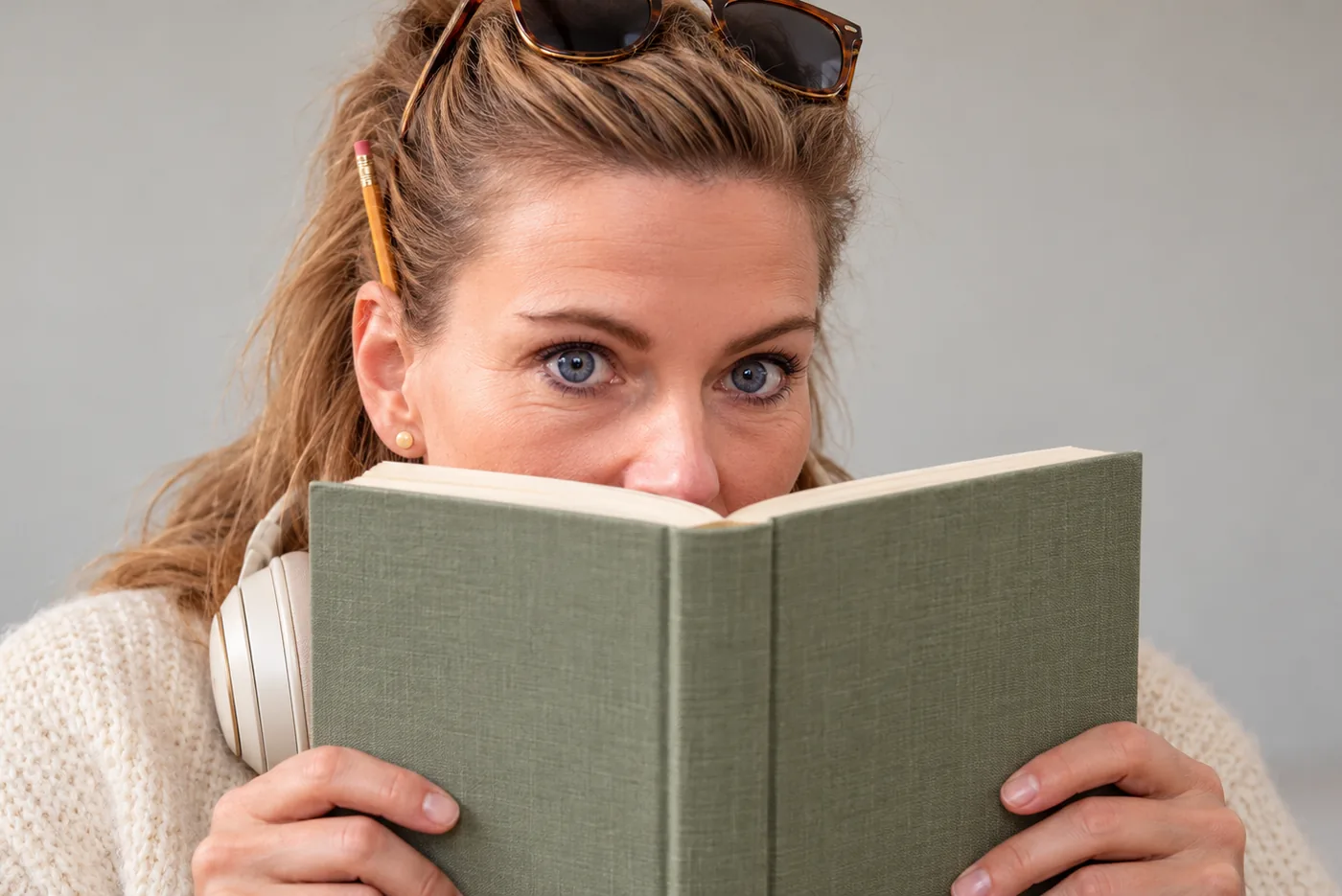Kristin Fuchs schaut neugierig über ein aufgeschlagenes Buch